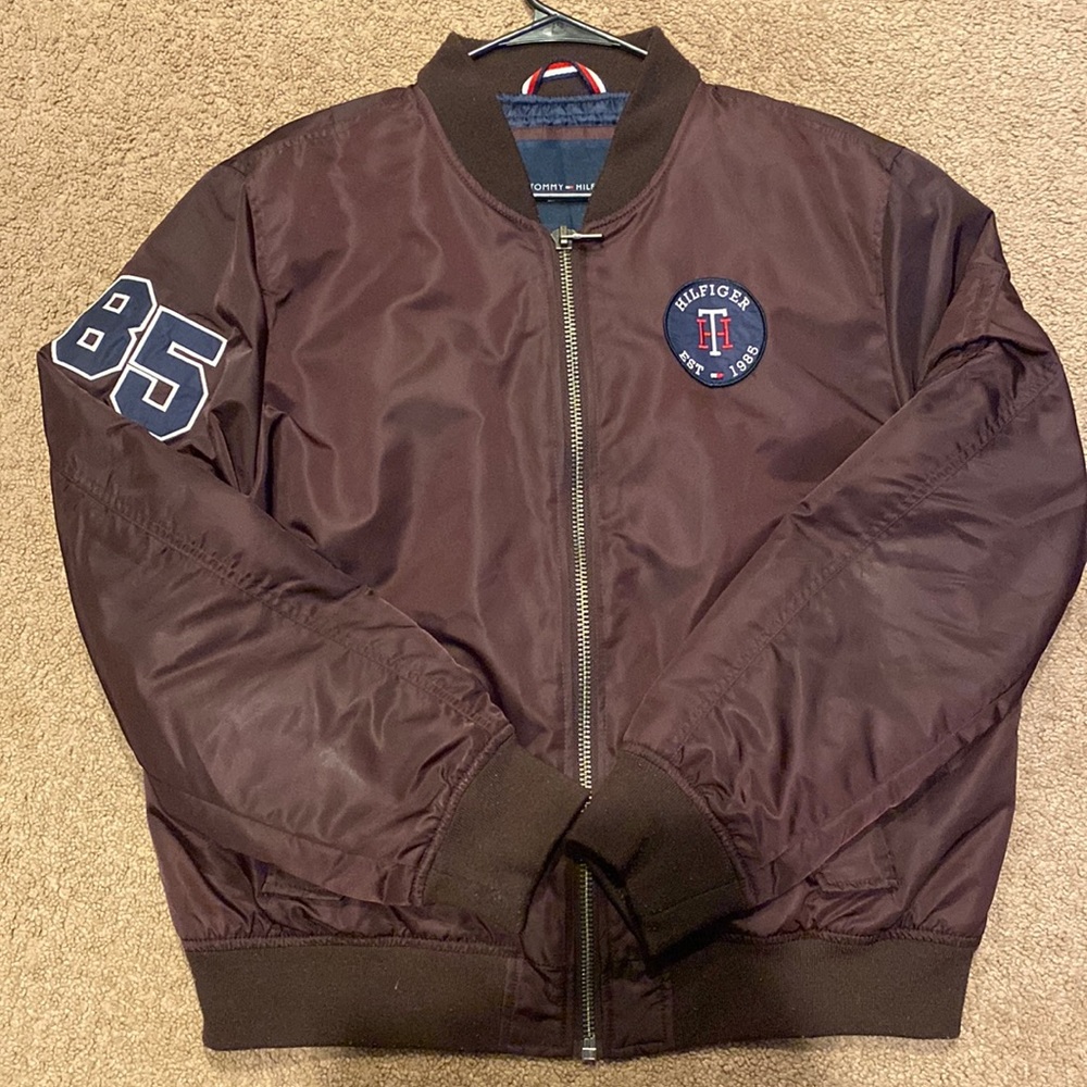 A burgundy no hooded Tommy Hilfiger bomber jacket.